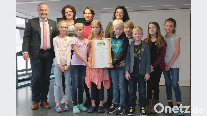 Stolz präsentieren die Schülerinnen und Schüler des Fairtrade-Teams der Albert-Schweitzer-Schule zusammen mit (von links nach rechts) Dr. Helmut Kollhoff, Rektorin Marion Weigl sowie Ingrid Lehnerer und Verena Kandziora ihre Auszeichnung als Fairtrade-Schule. Bild: Susanne Schwab, Stadt Amberg