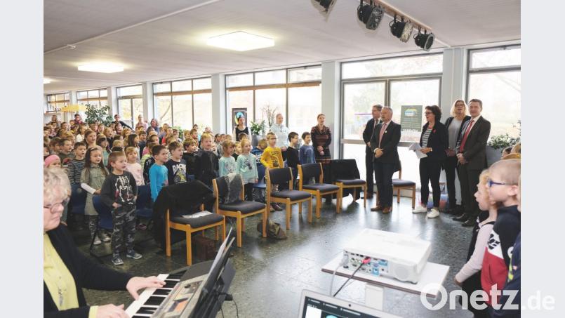 „Viele kleine Leute an vielen kleinen Orten, die viele kleine Schritte tun, können das Gesicht der Welt verändern“, sangen der Schulchor und alle Kinder der Albert-Schweitzer-Schule gemeinsam mit (von rechts nach links) Schulrat Geradl Haas, der stellvertretenden Elternbeiratsvorsitzenden Simone Rumpler, Rektorin Marion Weigl, Dr. Helmut Kollhoff sowie Oberbürgermeister Michael Cerny. Bild: Susanne Schwab, Stadt Amberg