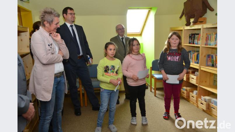 Kinder der Arbeitsgemeinschaft Demokratie stellen den Gästen die Schulbücherei vor. Bild: dob