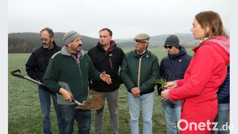 Landwirt Josef Hägler präsentiert den Interessenten aus Italien, Österreich, der Schweiz und Tschechien stolz eine Schaufel seiner extrem krümeligen Erde, die auch ohne Gülle und Kunstdünger eine reiche Ernte verspricht. Bild: Gerhard Götz