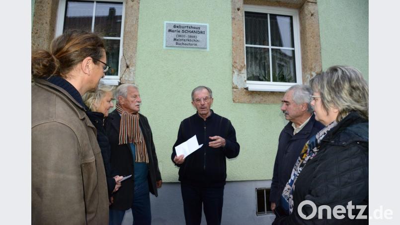 Am Gebäude Marktplatz 25 erinnert eine Tafel an die dort geborene spätere Meiisterköchin Marie Schandri, deren Todestag sich am 10. November zum 150. Mal jährte. Heimat- und Geschichtsforscher Josef Eimer (Mitte) berichtete den Mitgliedern von LuhKulTour über das Leben Schandris. Bild: bey
