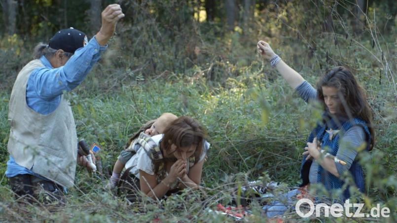 Ein Filmausschitt aus "Früher oder später": Sandra Hirsch (Mitte) mit Tochter bei einer schamanischen Pfeiffenzeremonie in der Nature Community. Bild: Zoe Schmederer