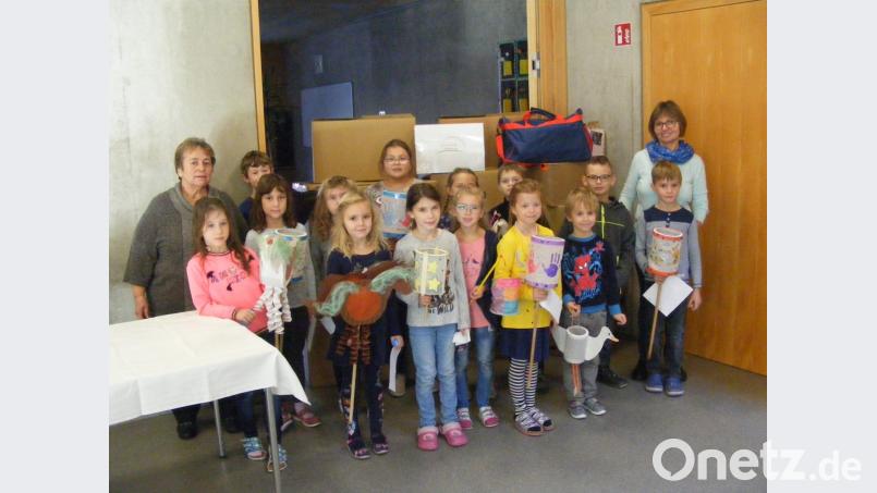 Das Bild zeigt einige Schüler mit Laternen zusammen mit Amanda Schmidt-Castillo (rechts) und Rektorin Irmgard Wittmann (links) bei der Übergabe der Spendenpakete. Bild: exb