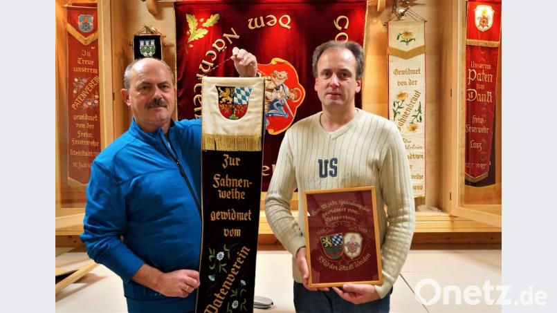 Vorsitzender Helmut Staratschek hält das Fahnenband, das die Neustädter zur Fahnenweihe vor 50 Jahren von der Weidener Feuerwehr geschenkt bekommen hat. Wolfgang Huber hält die Erinnerung zum 125-Jährigen in Händen (von links). Bild: arw