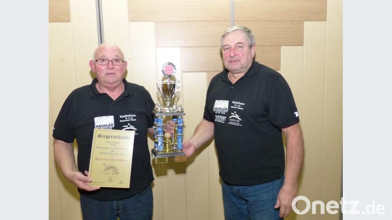 Reinhard Meiler (links) erhält aus Händen des Vorsitzenden Georg Rosner (rechts) den Wanderpokal und die Urkunde zur Clubmeisterschaft. Bild: hme