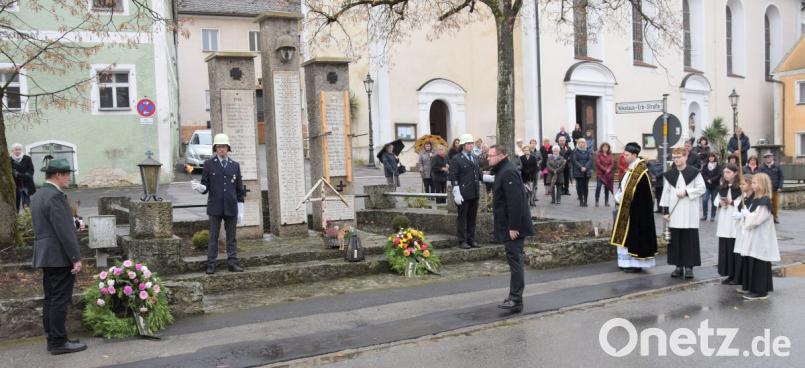 Zum Gedenken an die Gefallenen und Vermissten aus zwei Weltkriegen legten Bürgermeister Florian Junkes und Schützenmeister Josef Scharr (KSK-Tell- und Burgschützen) in Hohenburg einen Kranz am Kriegerdenkmal nieder. Die Trachtenkapelle umrahmte die Gedenkstunde. Bild: bö