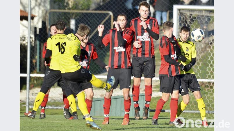 Der Amberger Spielmacher und Kapitän Heiko Giehrl (links) tritt einen direkten Freistoß über die Paulsdorfer Mauer, in die sich der FC-Führungstorschütze Alexander Greger (rechts) eingeschlichen hat. Bild: Ziegler