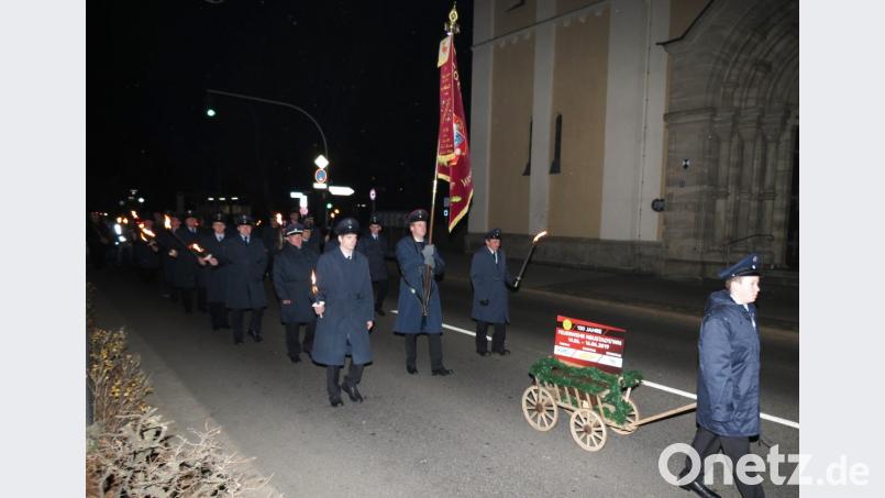 Mit FFW-Leiterwagen, Fahne und Fackelzug ging es zur Feuerwache nach dem Patenbitten. Bild: Dobmeier