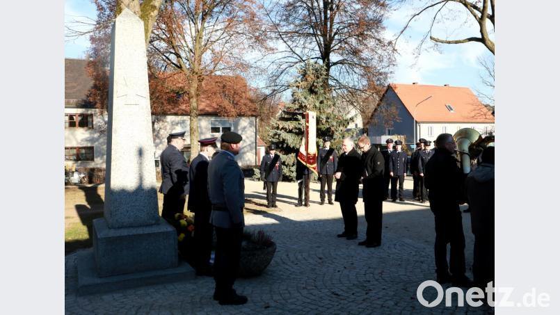 Vor dem Kriegerdenkmal in Wildenreuth legten (von links) zweiter Bürgermeister Johannes Reger und Pfarrer Manuel Sauer einen Kranz ab. Bild: njn