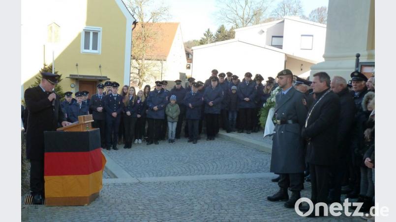 Peter Breitschafter (links) hielt als Vorsitzender der Soldatenkameradschaft Teunz die Gedenkansprache. Anschließend legte er zusammen mit Bürgermeister Norbert Eckl (rechts) einen Kranz am Kriegerdenkmal nieder. Bild: Portner