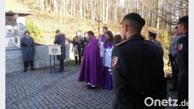 Mitglieder der Soldatenkameradschaft, der Feuerwehr und der Bundeswehr versammelten sich am Thansteiner Kriegerdenkmal um den Toten zu gedenken. Major Matthias Voß (am Rednerpult) und Pfarrvikar Benny Joseph Kochumundammalayil gestalteten den festlichen Akt. Bild: dl