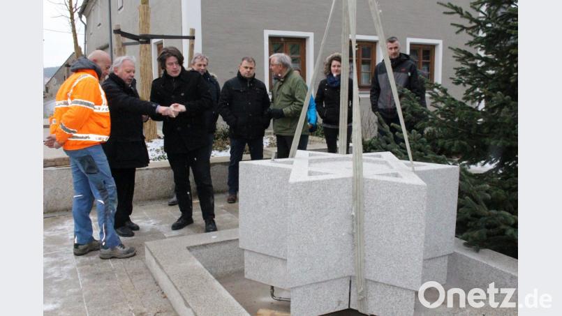 Künstler Harald Bäumler (Dritter von links) und Architekt Josef Schöberl (Zweiter von links) beobachten am Neuhauser Marktplatz, wie der Zoiglstern aus Granit millimetergenau angepasst wird. Bild: Lowak