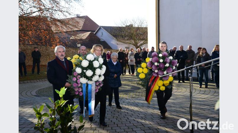 Bürgermeister Karl-Heinz Preißer (links) und die Vertreter der Vereine legen am Kriegerdekmal in Luhe Kränze nieder. Bild: bey