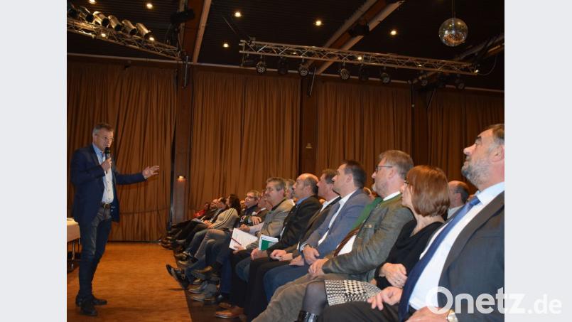 Waldmünchens Bürgermeister Markus Ackermann (links) berichtet den Oberhäuptern der elf Partnergemeinden und -städte in der Stadthalle Vohenstrauß von den Vorteilen einer tiefergehenden Zusammenarbeit in der ländlichen Entwicklung. Bild: dko
