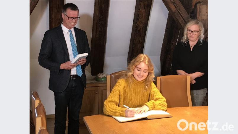 Nicole Allwang trägt sich unter den Augen von Bürgermeister Hermann Falk in das Goldene Buch der Stadt Hirschau ein. Bild: exb