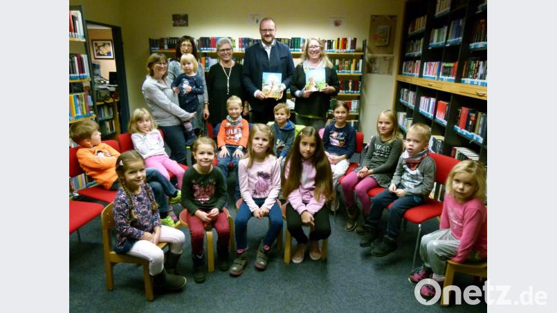 Auf einen Bauernhof und in die Steppen Afrikas entführt Landrat Andreas Meier (stehend, Zweiter von rechts) in der Stadtbibliothek die Mädchen und Buben beim Vorlesetag. Bild: rn