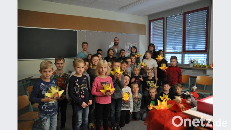 Mit Laternen in Sternform erhellen die Mädchen und Buben der Grundschule und des Förderzentrums den abgedunkelten Raum. Bild: ak
