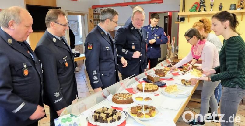 Natürlich unterstützen auch die aktiven Feuerwehrmänner die Aktion der Festdamen und nehmen für ihre Frauen eine Auswahl der angebotenen Kuchen mit nach Hause. Bild: wlr