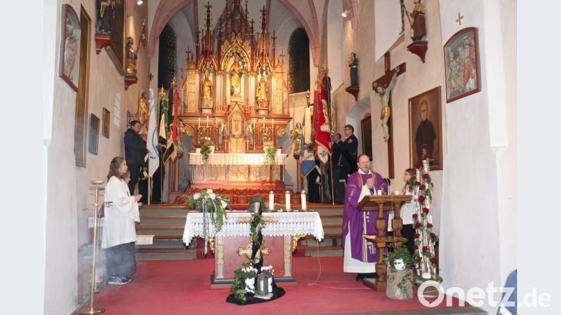 Pfarrer Heribert Stretz zelebriert die Messe. Im Hintergrund die Fahnenträger der teilnehmenden Vereine. Bild: rpp