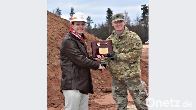 Schuldirektor Matthew Kralevich (links) freut sich, dass es mit dem Bau losgeht. Colonel John K. Baker (rechts), Leiter der Baubehörde der U.S. Army Europa, übergibt offiziell die Urkunde zum Spatenstich. Bild: rgr