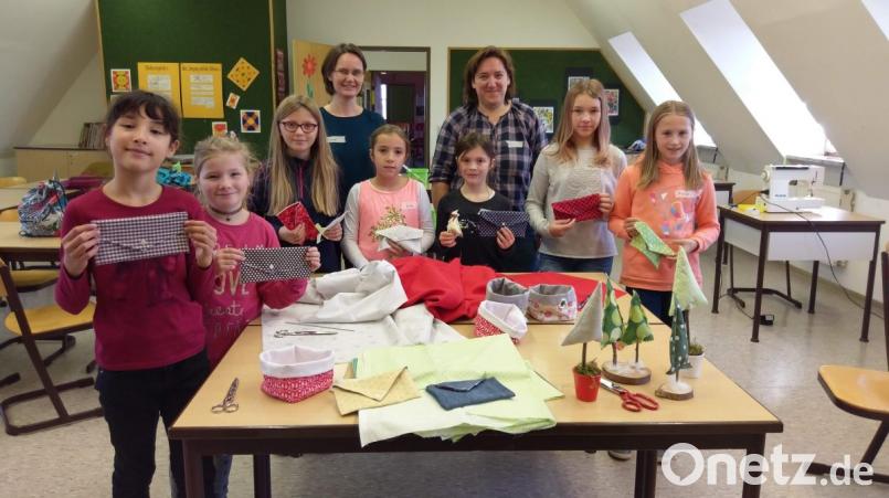 Stolz präsentieren die jungen Teilnehmerinnen am VHS-Kindernähkurs für Anfänger ihre Werke. Unter Anleitung von Kursleiterin Irene Weber und ihrer Assistentin Evi Kürzinger (hinten, von links) entstanden Stofftäschchen und Tannenbäumchen. Bild: mül