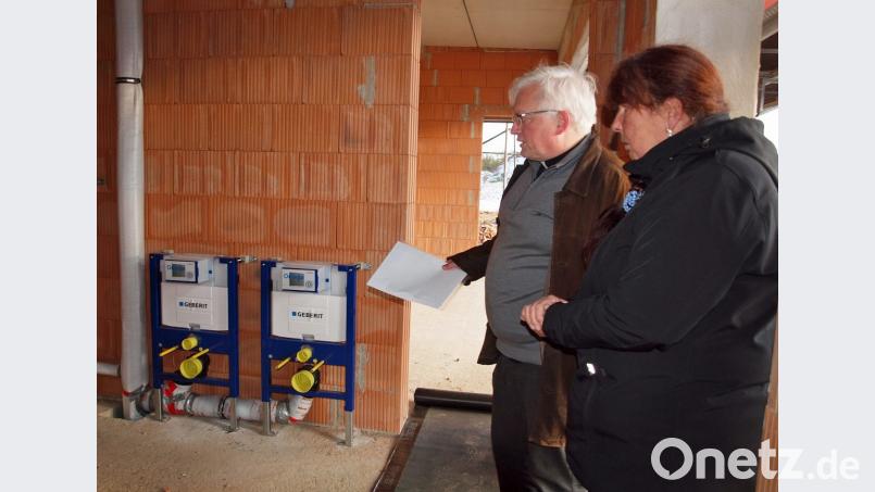 Auch Teile der Kindertoiletten sind schon angebracht, erläutert hier Pfarrer Gottfried Schubach. Bild: sön
