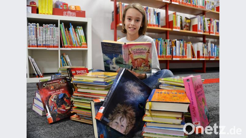 Ein Stapel Bücher: Das sind genau 62 Exemplare. Amelie verschwindet fast hinter dem Berg. Bild: spw