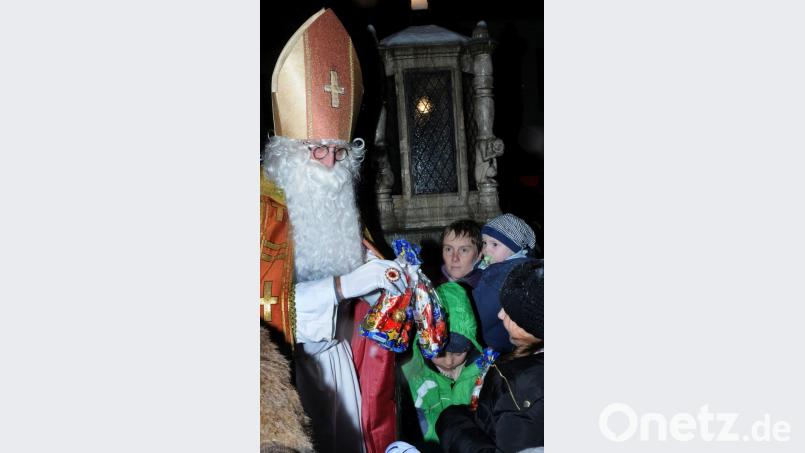 Jeder hat sein Packerl zu tragen. Auch der städtische Nikolaus, der es beim Alten Rathaus weiterverteilt. Bild: Stephan Huber