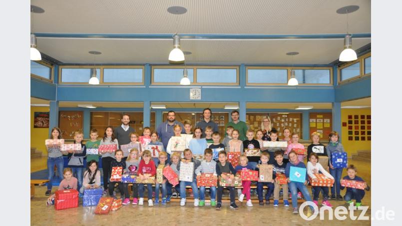 Severin Hirmer (links), Johannes Lang und Marc Lohse (Zweiter und Dritter von rechts) holten am Freitag die Weihnachtspäckchen ab. Lehrerin Karin Uhl (rechts) und Lehrer Thomas Troidl (Zweiter von links) unterstützen die Aktion. Bild: es
