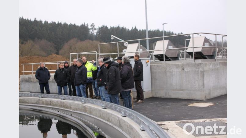 Günter Schwab (Leuchtjacke) erklärt den Gemeinderäten die Neuerungen auf der Kläranlage (im Hintergrund die Technik für das neue Zwischenhebewerk, vorne das Nachklärbecken). Bild: den
