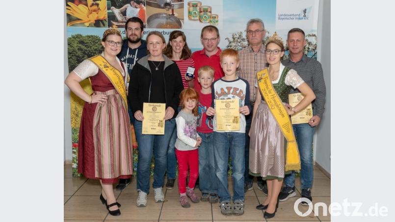 Bei der Ehrung (von links): Honigkönigin Doris Grünbauer, Stefan Hubmann, Petra Klughardt, Familie Stefan Riedl (fünf Personen), Helmut Heuberger, Honigkönigin Katharina Eder und Frank Pamler. Bild: exb