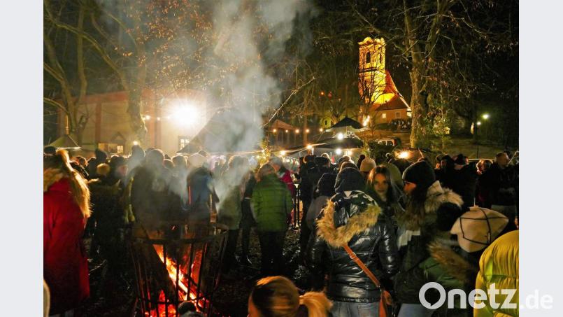Rund um einen Feuerkorb mit der beleuchteten Annabergkirche im Hintergrund verbreitet sich eine besondere Atmosphäre in der kleinen Zeltstadt. Bild: wbe