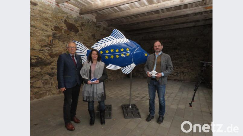 Stolz präsentieren Bernhard Feneis, Künstlerin Nicole Schulle rund Thomas Beer (v. li.) das Prachtstück, das nach Brüssel reist. Bild: ubb