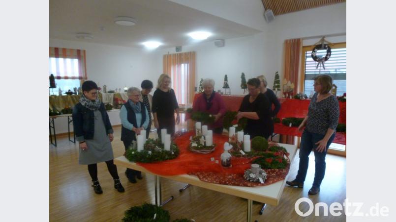 Stolz präsentieren die KDFB-Frauen ihre adventlichen Kreationen im Pfarrheim. Bild: rgl