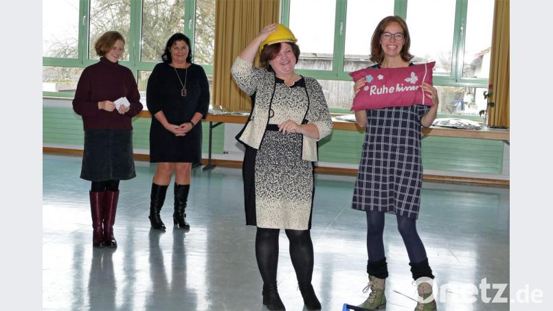 Wie sie die Arbeit der neuen Schulleiterin unterstützen werden zeigten die Lehrerinnen mit ihren Geschenken, unter anderem einem Bauhelm und einem Ruhekissen. Bild: wbe