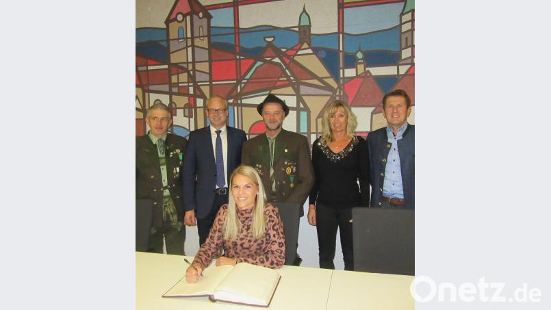 Julia Simon (vorne) trägt sich ins Goldene Buch der Gemeinde ein. Es freuen sich mit ihr Trainer Markus Bauer (von links), Bürgermeister Bernhard Lindner, Schützenmeister Werner Wendl sowie die Eltern Birgit und Norbert Simon. Bild: ufh