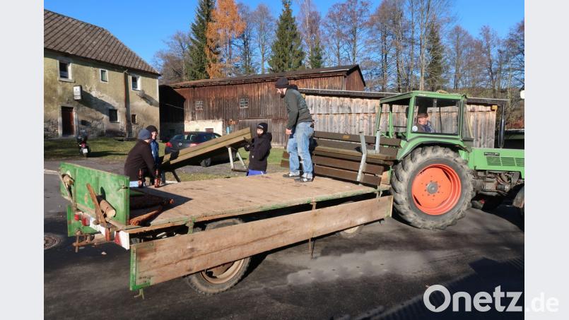 Bereits zum achten Mal unterstützt die Jugendorganisation „Stoawaldlerer“ den Arbeitskreis Tourismus bei der Ein- und Auslagerung der Ruhebänke. Thomas Trottmann, Jonas Henze, Kevin Radimerski und Johannes Kaßeckert (von links) verladen in Frauenreuth die Sitzgelegenheiten auf dem Hänger. Für die tatkräftige Unterstützung bei seinen zahlreichen Rundfahrten um den Erholungsort dankt Erwin Bächer (im Traktor) seinen „Boum“. Bild: bsc