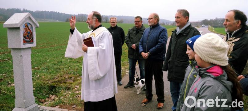 Diakon Peter Bublitz (von links) segnet vor den Augen des heutigen Neidl-Bauern Stefan Ehbauer, Bürgermeister Hermann Böhm, Erich Graf, Manfred Schwab und Heimatpfleger Rainer Hoffmann das Marterl. Bild: gf