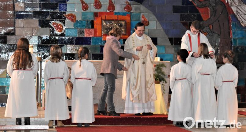 Gruppenleiter Jonas Ertl hängt den neuen Ministranten die Plakette um. Bild: rgr