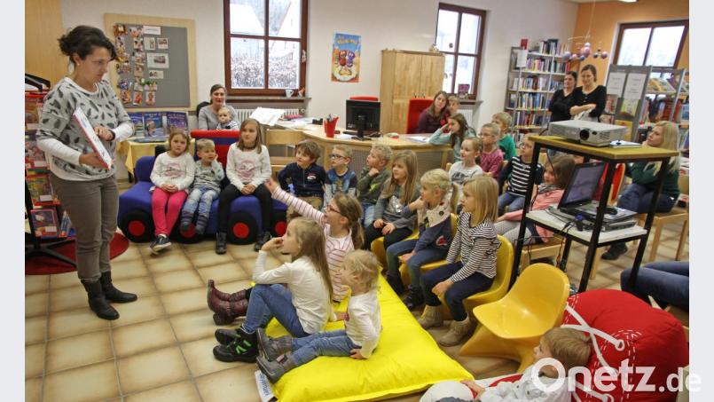 Maria Müller (links) versteht es, Kinder zu begeistern. Sie schafft mit ihrer Geschichte vorweihnachtliche Stimmung in der Bücherei. Bild: nm