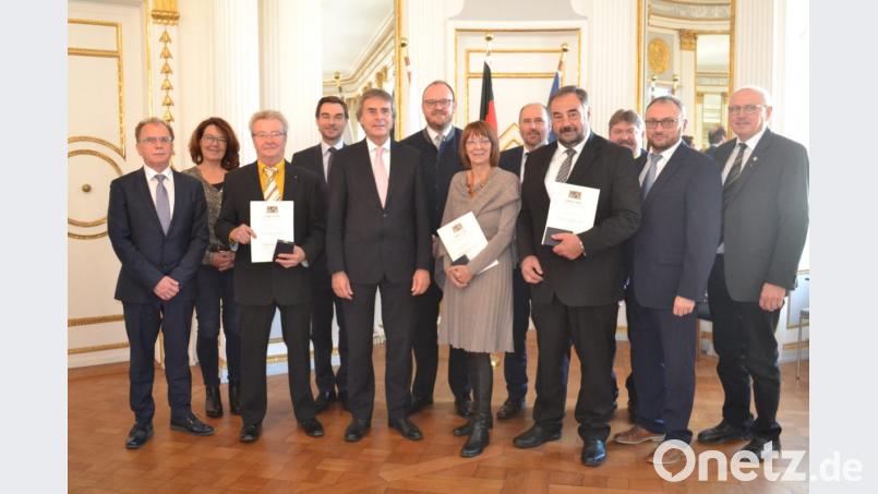 Ausgezeichnet werden (vorne, mit Urkunde, von links) Franz Floth, Margit Kirzinger und Josef Beimler. Regierungspräsident Axel Bartelt (vorne, Dritter von links) und kommunale Vertreter gratulieren. Bild: gib
