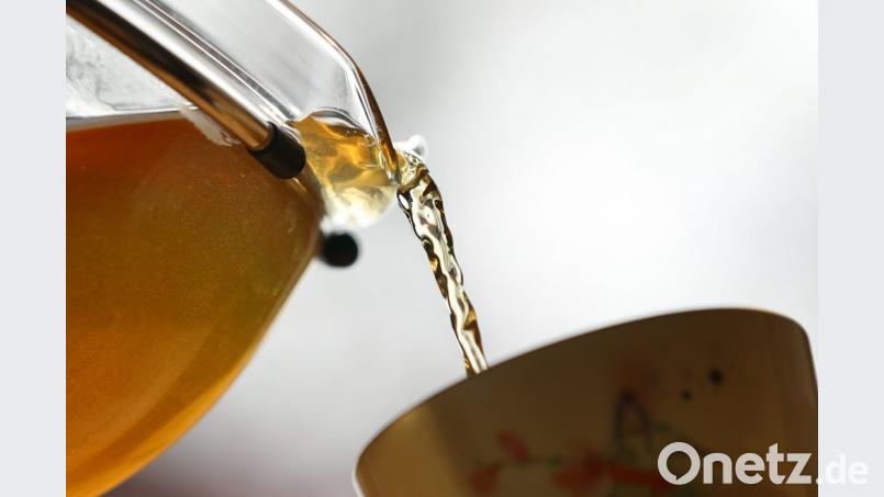 Grüner Tee wird in eine Tasse gegossen. Bild: Karl-Josef Hildenbrand/dpa