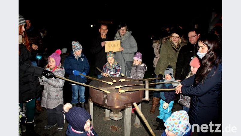 Die Kinder versammeln sich um den Feuerkorb und halten das Stockbrot ins Feuer. Bild: zer