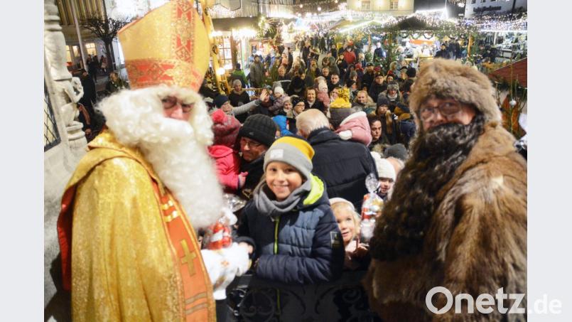 Kein Kind geht leer aus. Der Nikolaus, Knecht Ruprecht und die anwesenden „Stadtrats-Engel“ um Bürgermeister Lothar Höher verteilen bei der Christkindlmarkteröffnung Süßigkeiten. Bild: Gabi Schönberger
