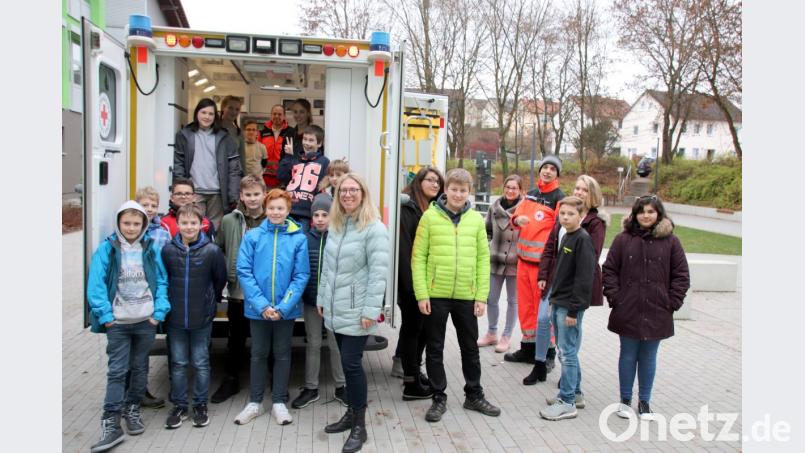 &quot;Macht ruhig alle Schubladen auf&quot;, fordert Timo Battaglia (Vierter von rechts) die Schulsanis und ihre Lehrerin Susanne Hahn (vorne, Mitte) auf. Das ließen sich die interessierten Schüler nicht zweimal sagen und inspizieren den Rettungswagen des Roten Kreuzes gründlich. Bild: gac