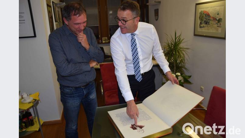 Bürgermeister Franz Stahl (rechts) und Pressesprecher Mirko Streich bestaunen das unbenutzte „Goldene Buch“ aus dem Jahr 1964. Bild: exb