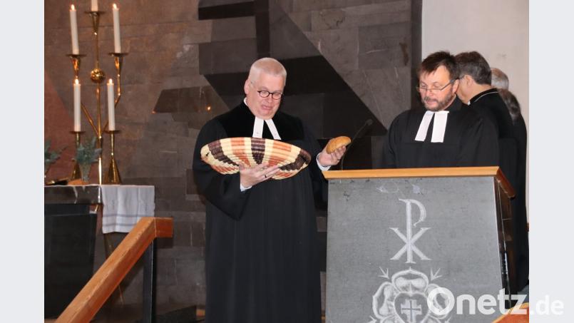 Pfarrre Klaus Eberius (links), der Beauftragte des Dekanats für Brot für die Welt, reichte jedem Fürbittensprecher, hier der brasilianische Austauschpfarrer von Schwandorf, Alfredo Malikoski, ein Brot. Bild: cog