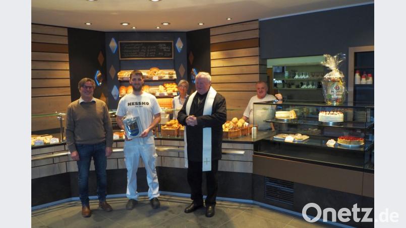 Pfarrer Erwin Bauer segnet im Beisein von Bäckermeister Matthias Karl und Bürgermeister Reiner Gäbl (von rechts) sowie Petra und Erhard Karl das neugestaltete Bäckergeschäft. Bild: gz