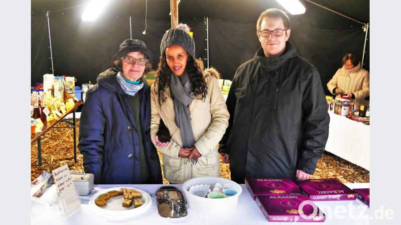 Die junge Azeb aus Eritrea bot arabische Süßigkeiten an , unterstützt von der Integrationsbeauftragten der Pfarrei Irmgard Renner und Kaplan Daniel Fenk. Bild: wbe