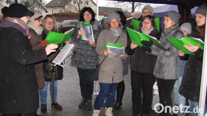 Der Singkreis unter Leitung von Susanne Hausmann erfreut neben Posaunenchor und Kinderchor mit "Wildvoices" mit weihnachtlichen Weisen. Die Chöre stehen in einem großen Pavillon im Trockenen . Keiner lässt sich vom Regen die vorweihnachtliche Stimmung verderben. Bild: sei